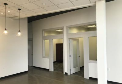 Modern reception area with pendant lights and glass-door private offices.