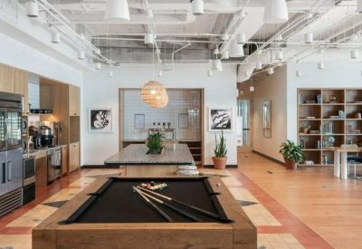 Communal break area featuring a pool table, modern kitchen, and wooden flooring.