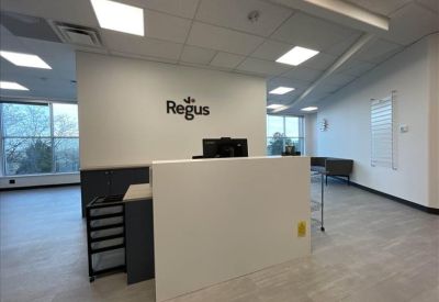 Bright reception area with a white desk and branded signage.
