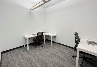 Two-person private office suite with white desks and wood-style flooring.
