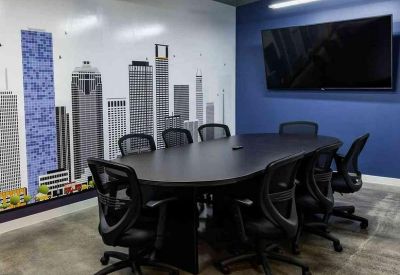 Modern conference room featuring a large oval table, mesh chairs, and a colorful city skyline mural.