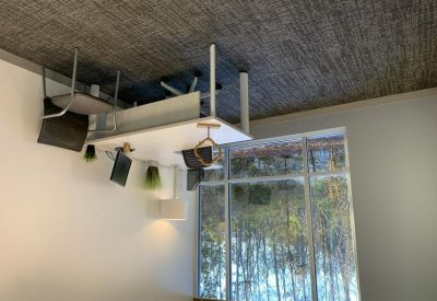 Private office suite with a white desk and view of the surrounding woods.