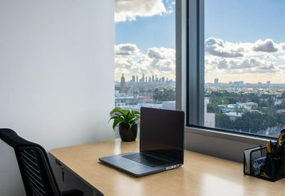 Private desk setup by a large window overlooking the city skyline.