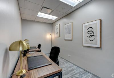 Two-person private office with wooden desks and framed wall art.
