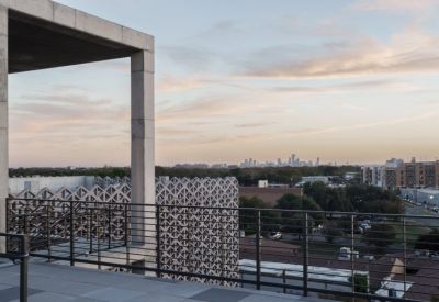 Rooftop terrace overlooking the Austin skyline at sunset with a decorative geometric screen.