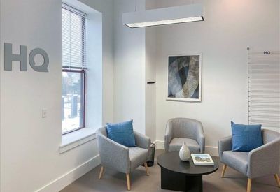 Comfortable seating area with grey tub chairs and a round coffee table.