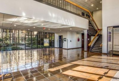 Bright multi-level lobby featuring a grand staircase and polished reflective floors.