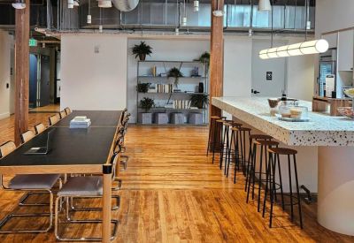 Communal kitchen and dining area with a terrazzo island and hardwood floors.