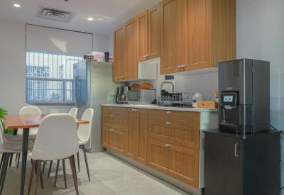 Kitchen and dining area with wooden cabinets and a modern coffee machine.