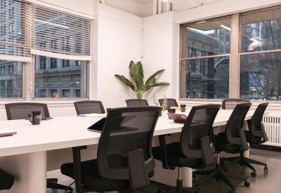 Conference room featuring large windows with city views and a white boardroom table.