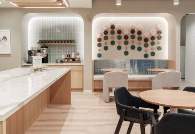 Bright kitchen and cafe area with a marble island and colorful wall art.