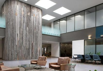Spacious reception lobby with a curved reclaimed wood feature wall and leather seating.