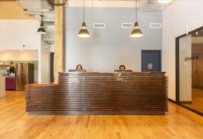 Reception desk with a wood-slatted front and modern pendant lighting.
