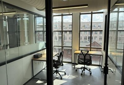 Two-person glass-walled office with natural light.