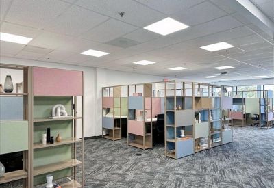 Spacious coworking area with colorful shelving units used as room dividers.