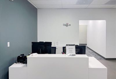 White minimalist reception desk in front of a blue accent wall.