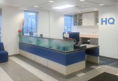 Professional reception area with a blue and white front desk and frosted glass accents.