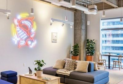 Bright common area featuring a colorful neon wall art piece and comfortable seating.