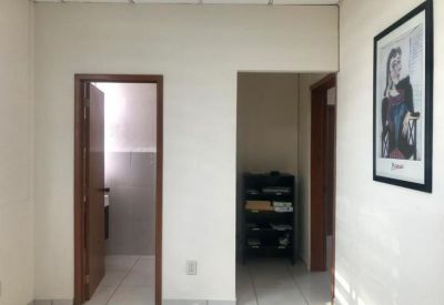 Internal hallway leading to a restroom and a storage area with framed wall art.