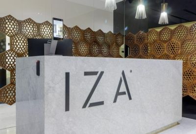 Modern marble reception desk with the company logo and honeycomb-patterned wall dividers.