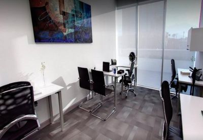 Private office space with several black ergonomic chairs and abstract wall art.
