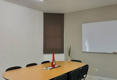 Conference room with an oval wooden table and large whiteboard.