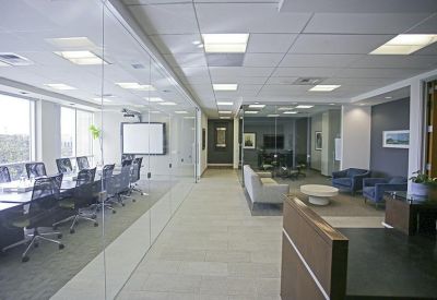 Modern open-plan lounge and reception area with a glass-walled conference room.