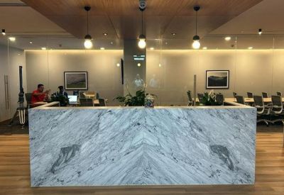 Marble reception desk with pendant lighting and wood ceilings.