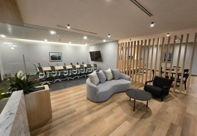 Conference room with a long table and ergonomic chairs next to a lounge space.