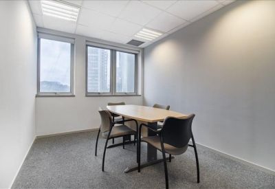Private office suite with a meeting table and large windows.