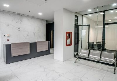 Modern lobby with a dark grey reception desk and silver guest seating area.