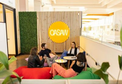 Casual lounge area with colorful bean bags and the Oasaw logo on a wooden wall.
