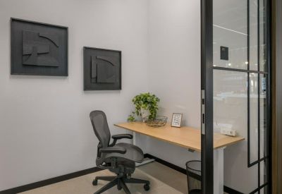 Small private meeting room or phone booth with a built-in desk and modern wall art.