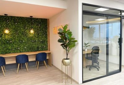 Modern workspace with a green living wall and private glass-walled office suite.