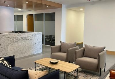 Modern lounge area with a marble reception desk and blue velvet sofa.