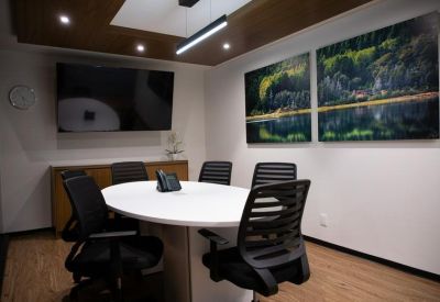 Small meeting room with an oval white table and nature-themed wall art.