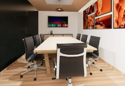 Formal boardroom featuring a long light-wood table and vibrant landscape photography.