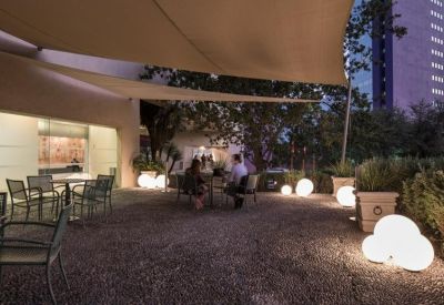 Outdoor communal terrace at dusk with glowing globe lights and patio seating.