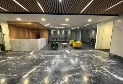 Spacious reception lobby with a marble floor and modern wooden slat ceiling.