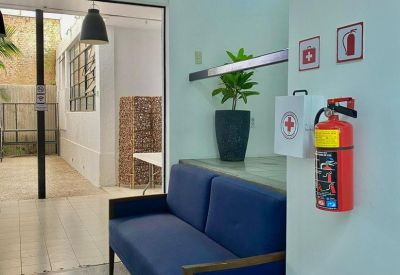 Lounge area with a blue sofa, indoor plant, and emergency safety equipment.