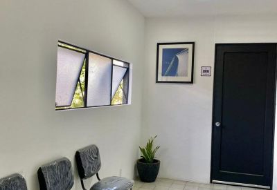 Waiting area featuring black chairs, tiled floor, and a framed art piece.