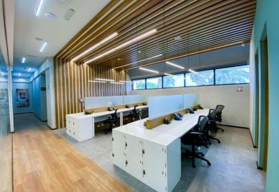 Open-plan workspace with white desks and a slatted wood feature ceiling.