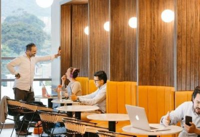 Casual meeting area with bright yellow booths and laptops.