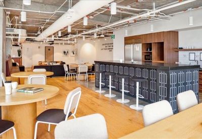 Spacious communal kitchen area with a large island, bar seating, and industrial ceiling.