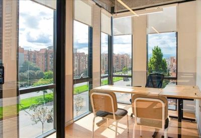 Bright corner office with floor-to-ceiling windows offering city views.