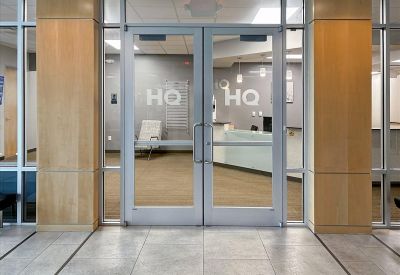 Main entrance to East Pointe 200 at 3420 Atrium Boulevard with glass double doors and a reception view.