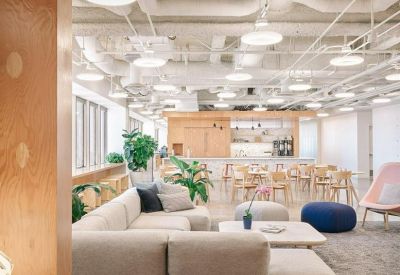 Spacious communal lounge at Equitable Plaza with modular sofas and exposed white ceiling ductwork.