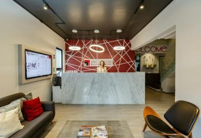 Modern reception area with a marble desk and geometric red feature wall.