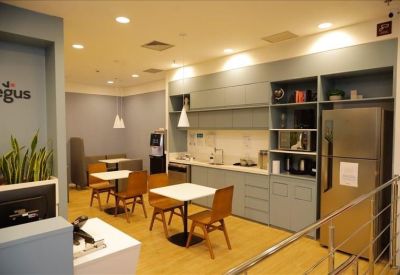 Communal kitchen and dining area with modern cabinetry and light wood flooring.