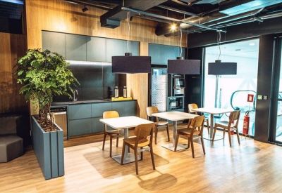 Bright breakout area with cafe seating and a modern kitchenette.